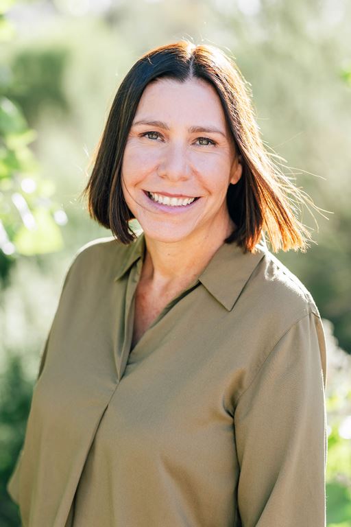 KG headshotFINAL - Alliance for Water Efficiency Woman smiling outdoors in sunlight, wearing an olive green blouse with a collar.